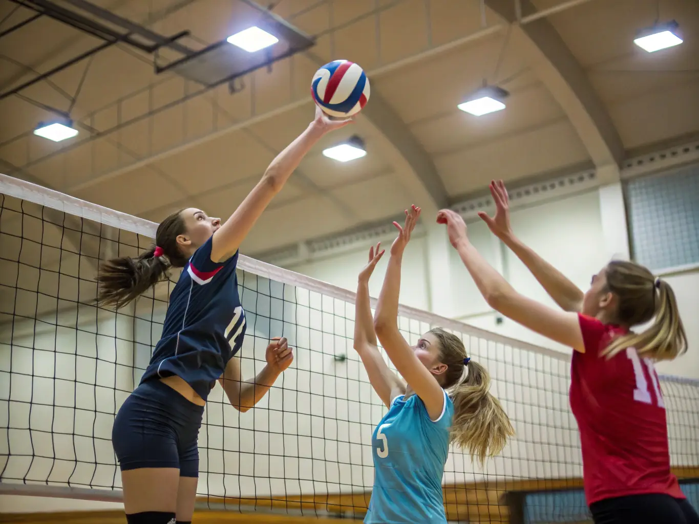 An action shot of adults playing a competitive volleyball match at the USLS sports hall, demonstrating skill and camaraderie.